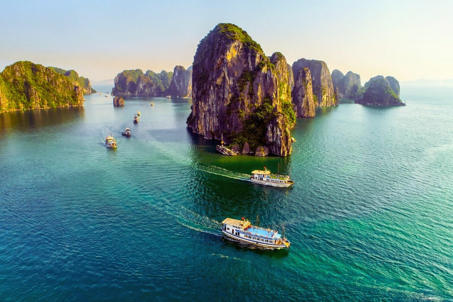 Halong Bay cruise boats sailing between limestone karsts and emerald waters &ndash; Vietnam